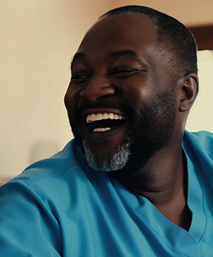 African American Physical therapist laughs with a patient