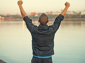 Man raises arms in triumph